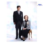 静岡で叙勲を祝うご夫婦の記念写真。モーニング姿のご主人とコサージュをつけた奥様