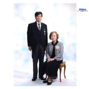 静岡で叙勲を祝うご夫婦の記念写真。モーニング姿のご主人とコサージュをつけた奥様